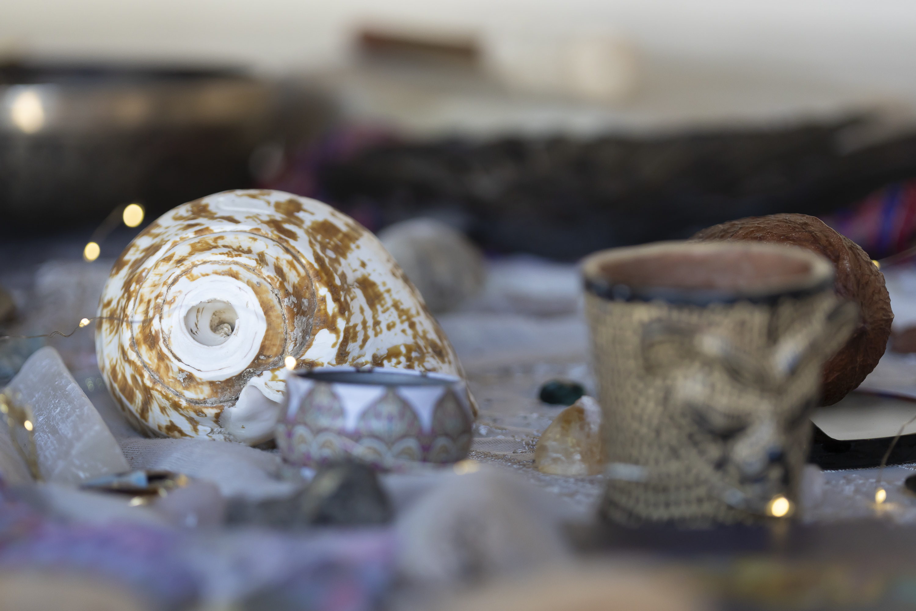 Shell, patterned cup, and crystal details from a Camp Cabo ritual table.