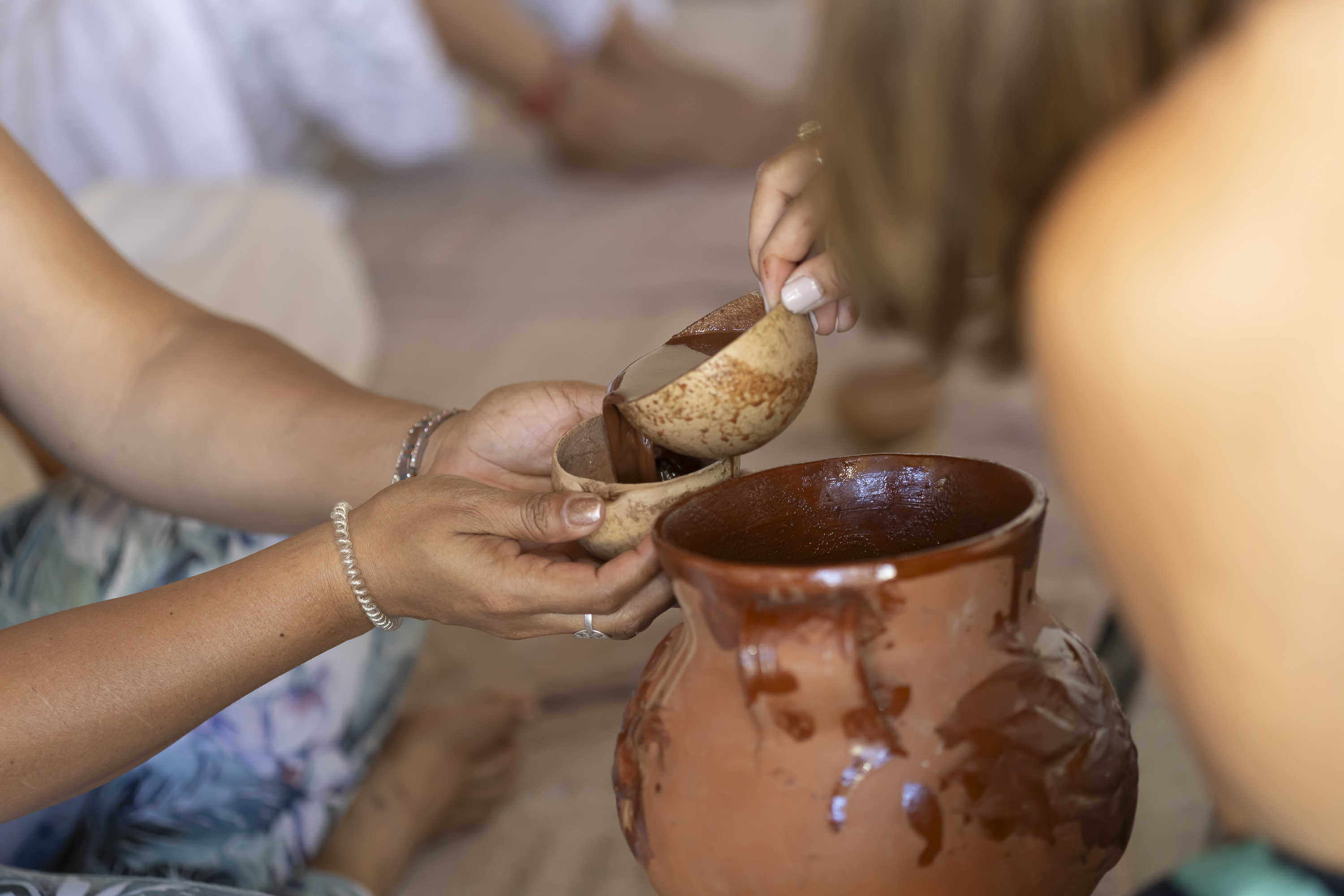 Ceremonial cacao being poured into a cup during a private group ritual.