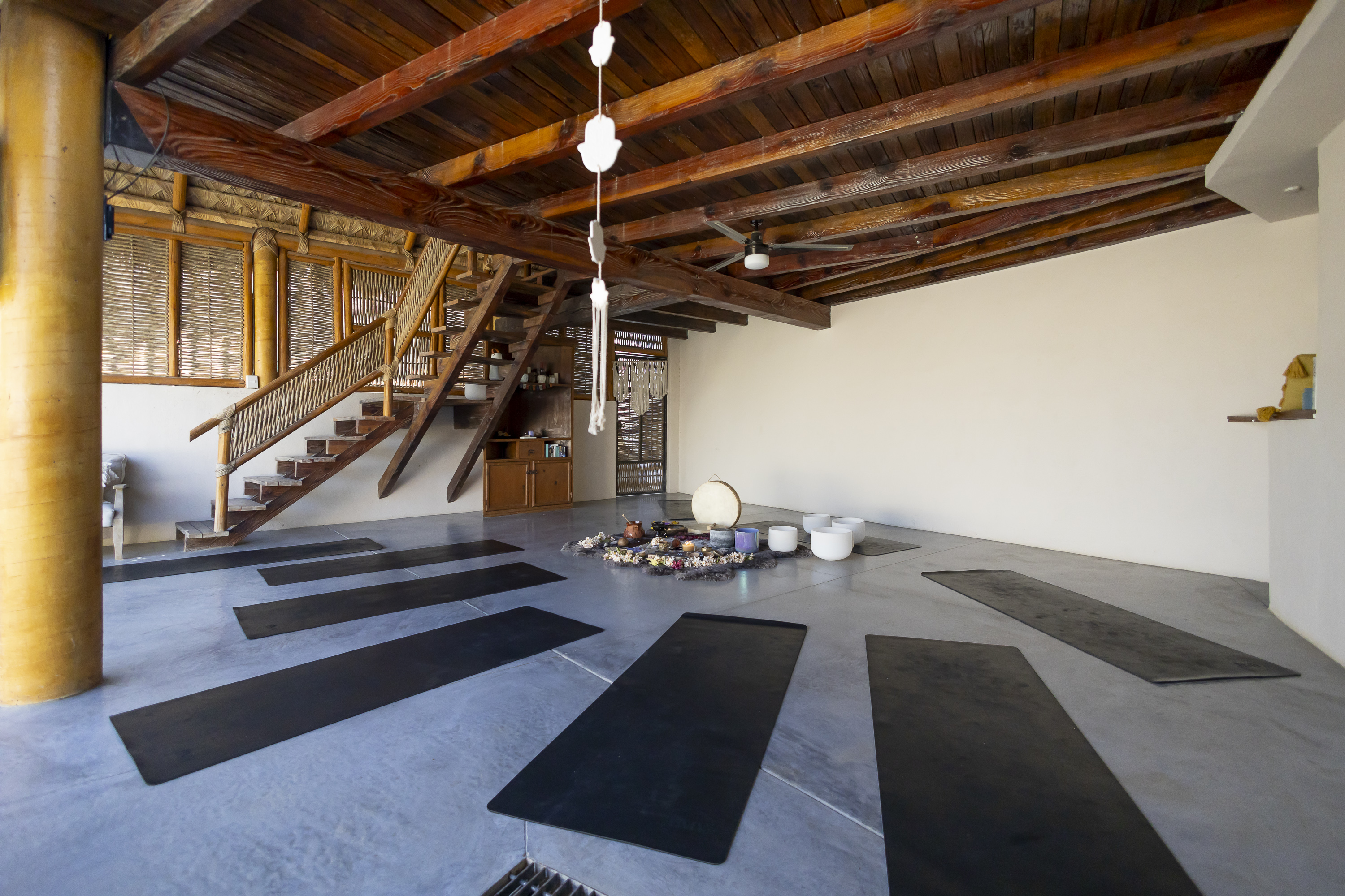 Camp Cabo studio with yoga mats, wood beams, and an open room prepared for private sessions.