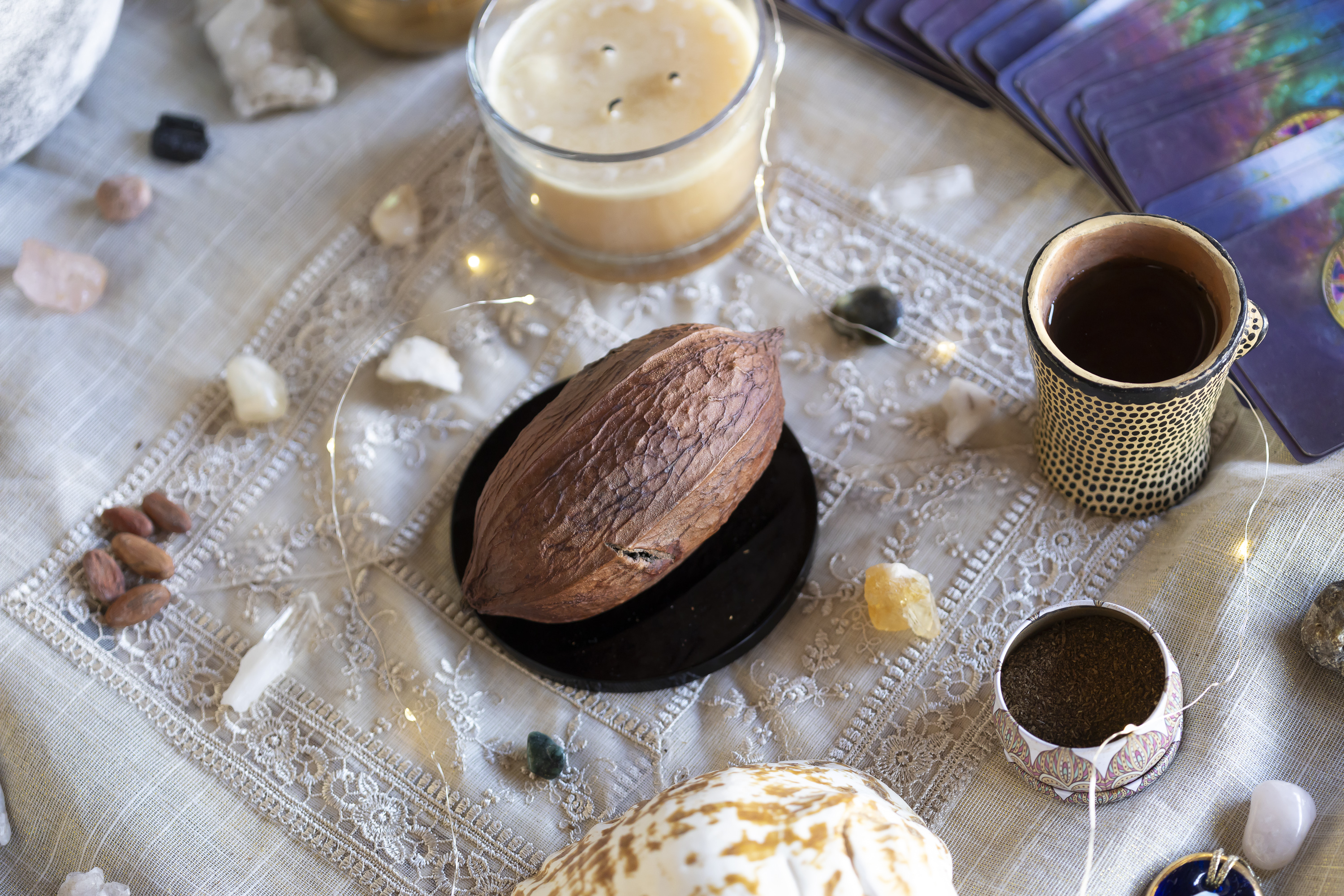 Cacao bean, candle, and cup details from a Camp Cabo ritual setup.