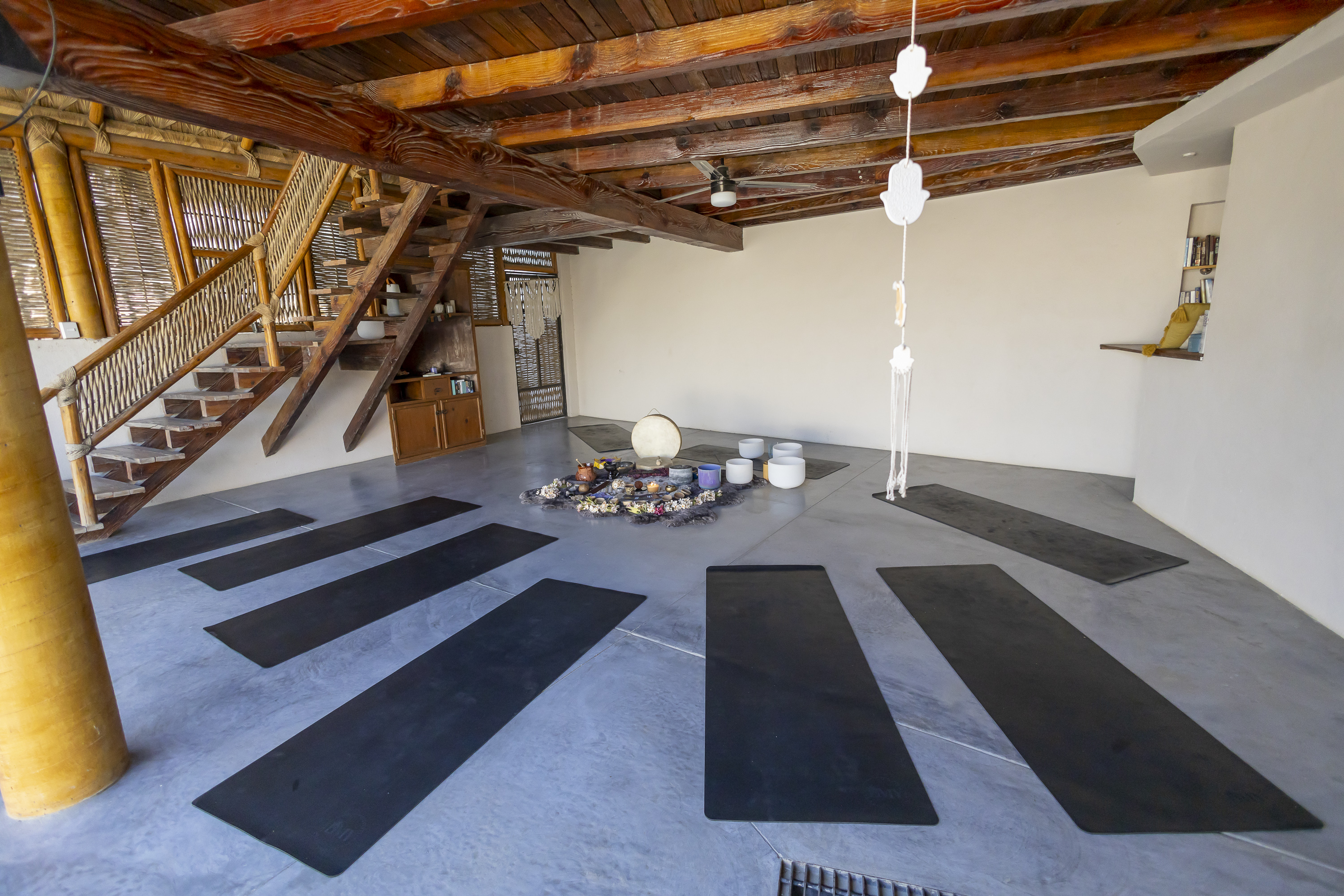 Camp Cabo studio with wood beams, woven railings, and open floor space for private sessions.